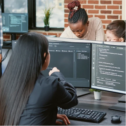 Developers reviewing code on computer monitors